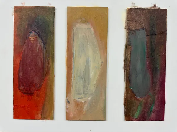Three narrow upright panels side by side, each holding one soft oval: dark red on orange, pale cream on ochre, grey-green on brown